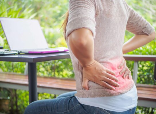 Pregnant woman receiving a massage on her lower back for pain relief