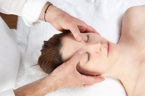 Woman receiving massage therapy for headache relief.